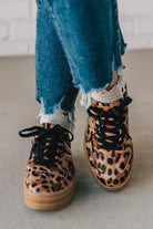 Leopard print sneakers with gold accents and black laces.