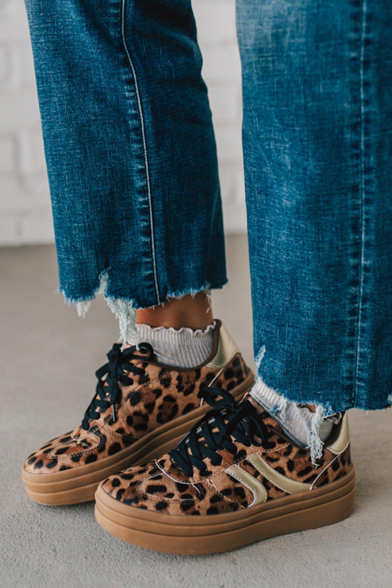 Leopard print sneakers with gold accents and black laces.