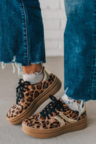 Leopard print sneakers with gold accents and black laces.