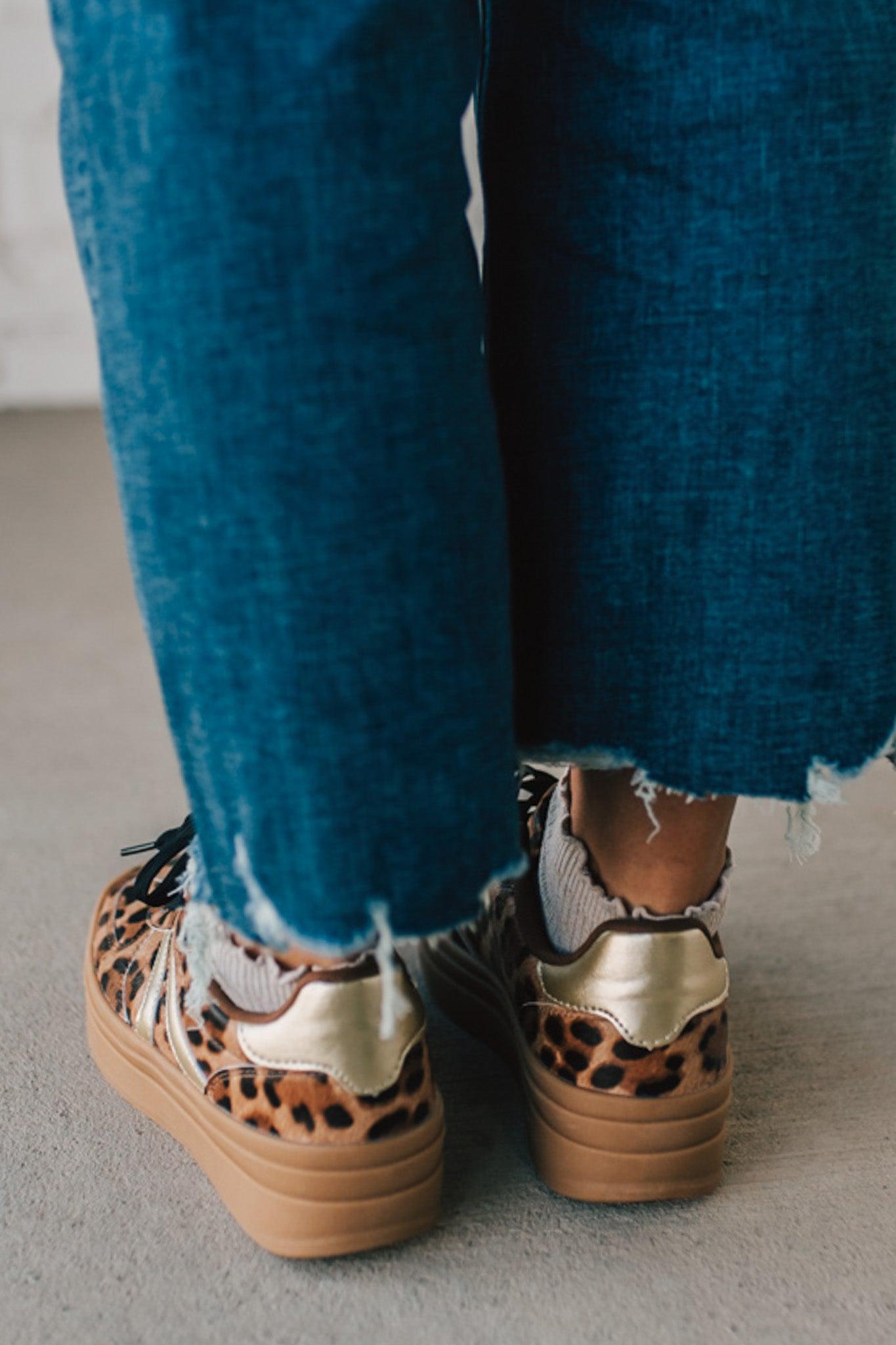 Leopard print sneakers with gold accents and black laces.