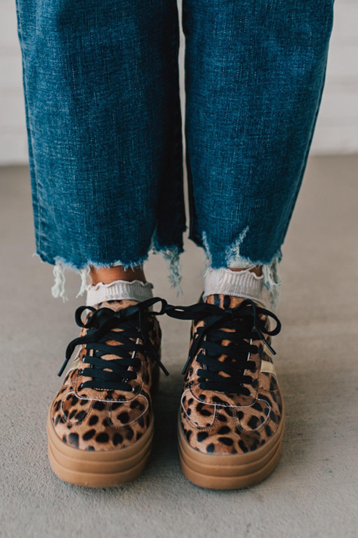 Leopard print sneakers with gold accents and black laces.