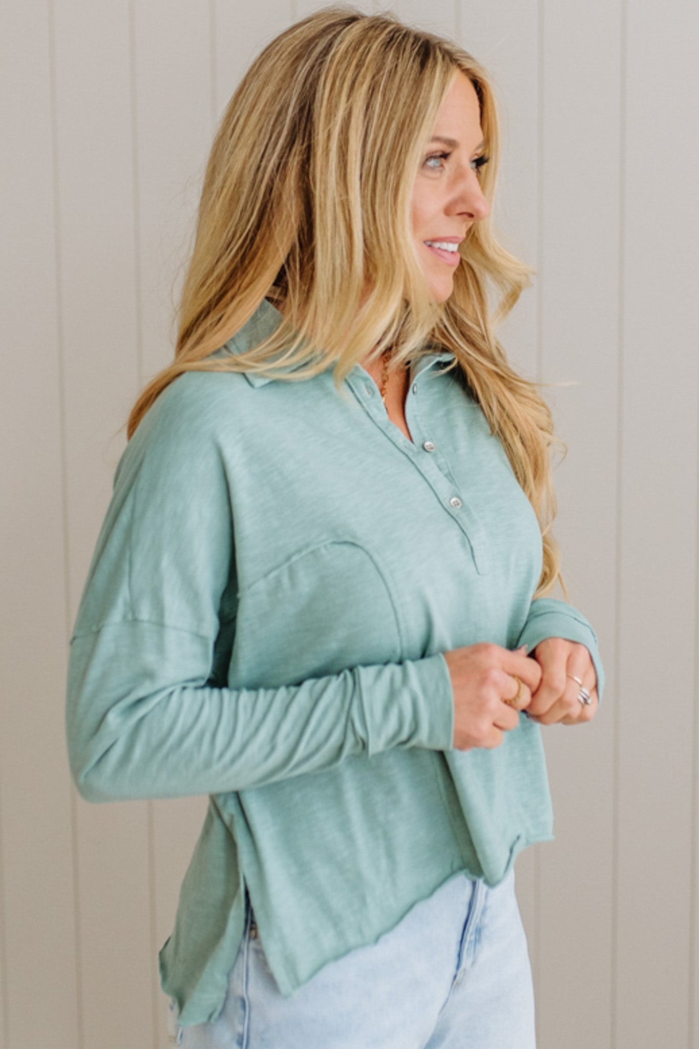 Woman wearing a light green shirt against a neutral background