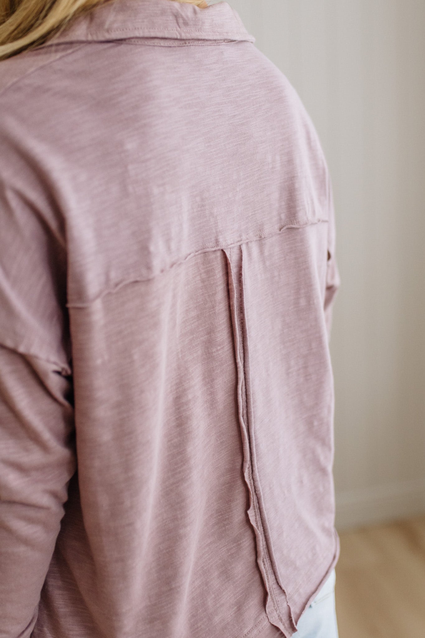 Close-up of a pink shirt worn by a person with a neutral background