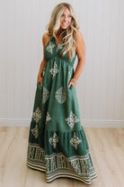 Woman wearing a green dress with white patterns in a minimal indoor setting