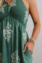 Green dress with white embroidery on a plain background