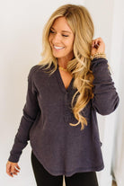 Woman wearing a dark navy long-sleeve top against a white background