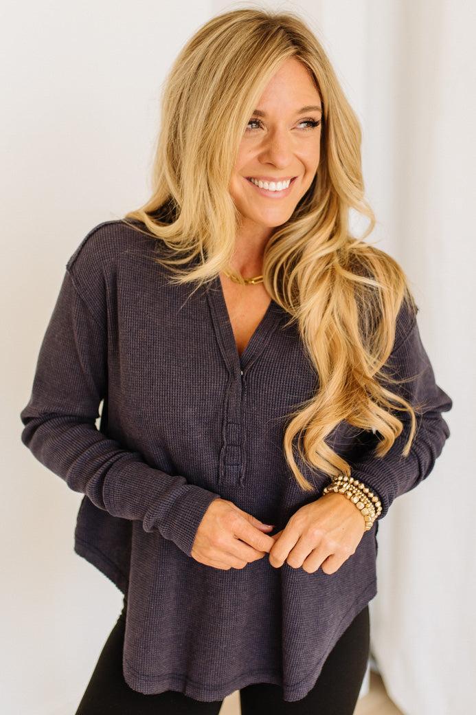Woman wearing a dark navy long-sleeve shirt against a white background