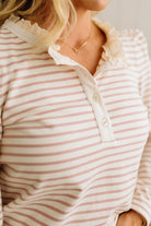 Close-up of a person wearing a striped shirt with lace trim