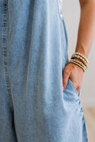 Person wearing light blue jeans with a neutral background