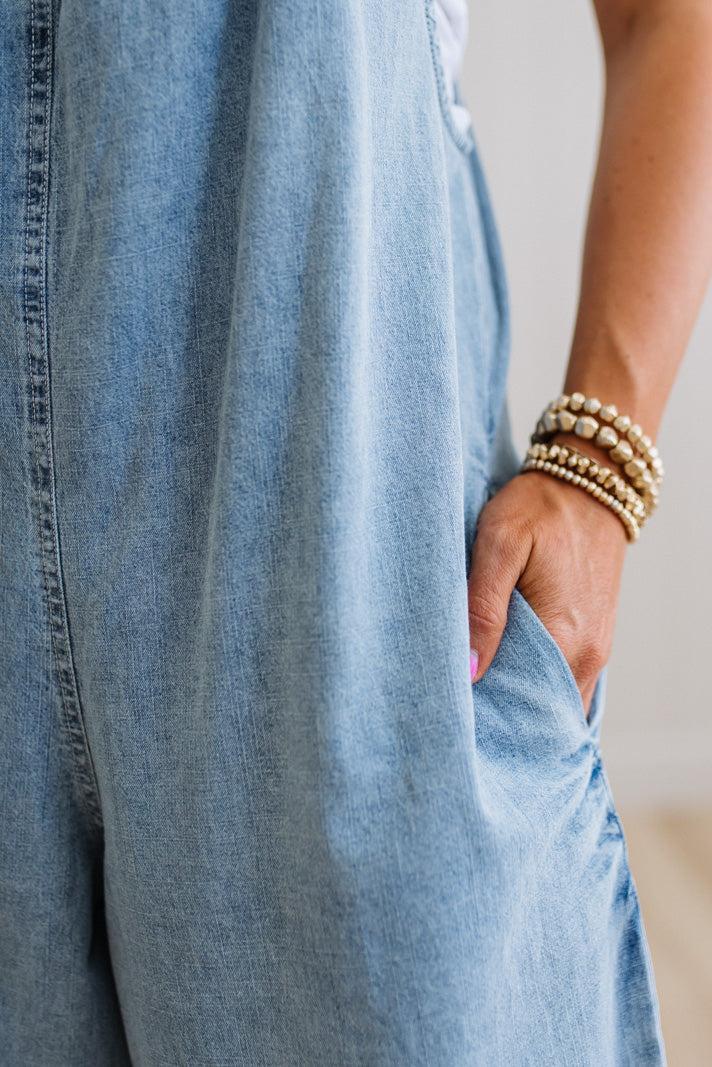 Person wearing light blue jeans with a neutral background