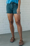 women wearing mid rise frayed shorts that have a black mineral wash finish