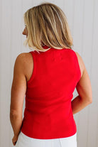 Person wearing a red sleeveless top against a plain background