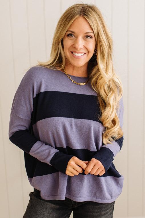 Woman wearing a color-blocked sweater against a plain background