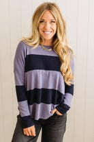 Woman wearing a striped sweater with a plain background