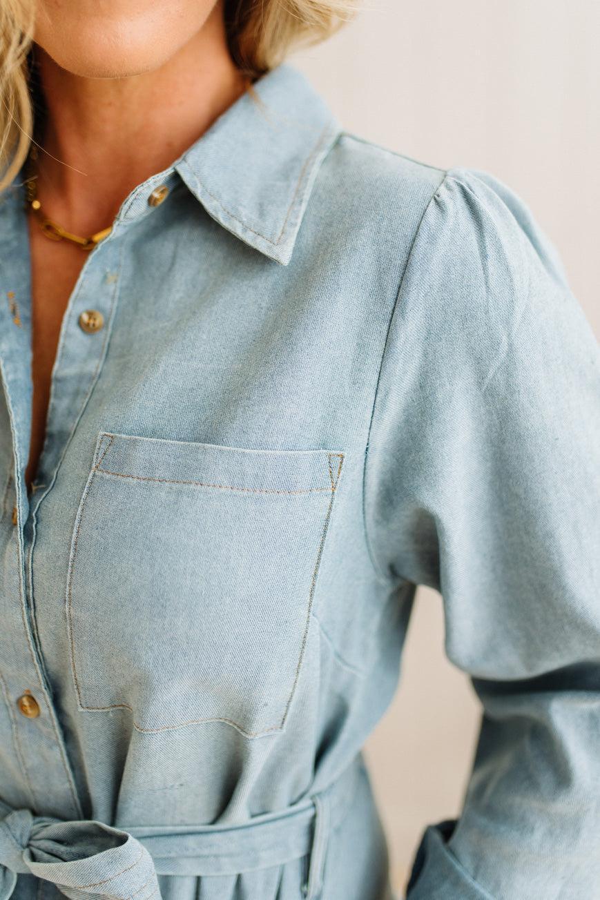 Light blue denim dress worn by a person on a neutral background