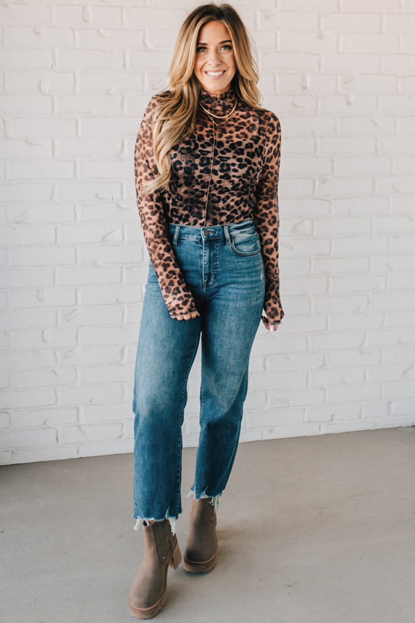 BLONDE WOMAN WEARING ANIMAL PRINTED LETTUCE EDGE MESH MOCK NECK TOP