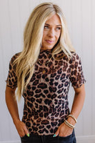 Woman wearing a leopard print top with a plain background