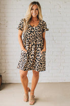 BLONDE WOMAN WEARING A LEOPARD PRINT WOVEN PUFF SLEEVES DRESS WITH PATCH POCKETS.