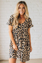 BLONDE WOMAN WEARING A LEOPARD PRINT WOVEN PUFF SLEEVES DRESS WITH PATCH POCKETS.