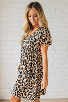 BLONDE WOMAN WEARING A LEOPARD PRINT WOVEN PUFF SLEEVES DRESS WITH PATCH POCKETS.