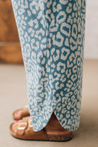 BLONDE WOMAN WEARING WASHED LEOPARD PATTERN PANTS WQITH CURVED SIDE SEAM AND WITH DRAWSTRING WAIST.
