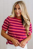 Woman wearing a red and blue striped shirt against a plain background