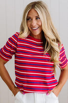Woman wearing a red and blue striped shirt with a plain background