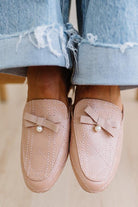 Pink loafers with bow and pearl detail worn with light blue jeans.