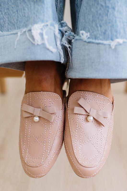 Pink loafers with bow and pearl detail worn with light blue jeans.