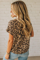 Woman wearing a leopard print top with a white brick wall background