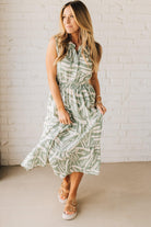 Blonde Woman Wearing a Button Up Sleeveless Smocking Waist Abstract Dress.