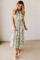 Blonde Woman Wearing a Button Up Sleeveless Smocking Waist Abstract Dress.