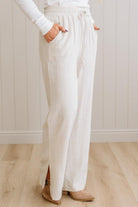 Person wearing white pants with a plain background