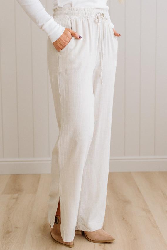 Person wearing white pants with a plain background