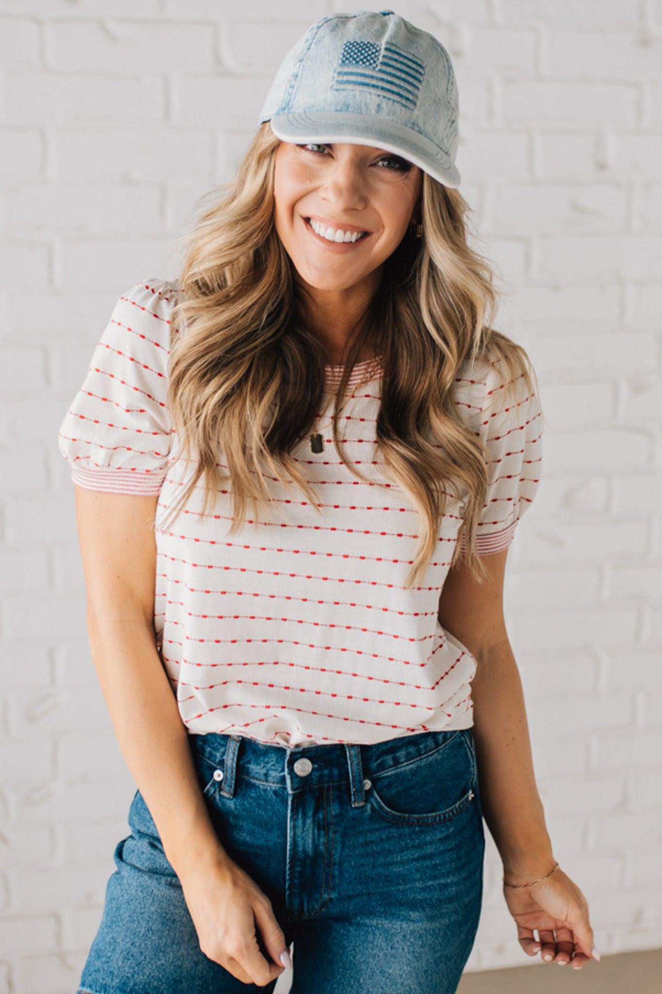 BLONDE WOMAN WEARING A STRIPE CONTRAST TRIMMED, PUFF SHORT SLEEVE, DOTTED STRIPE TOP IN WHITE AND RED.