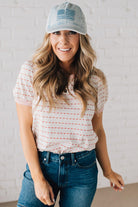 BLONDE WOMAN WEARING A STRIPE CONTRAST TRIMMED, PUFF SHORT SLEEVE, DOTTED STRIPE TOP IN WHITE AND RED.