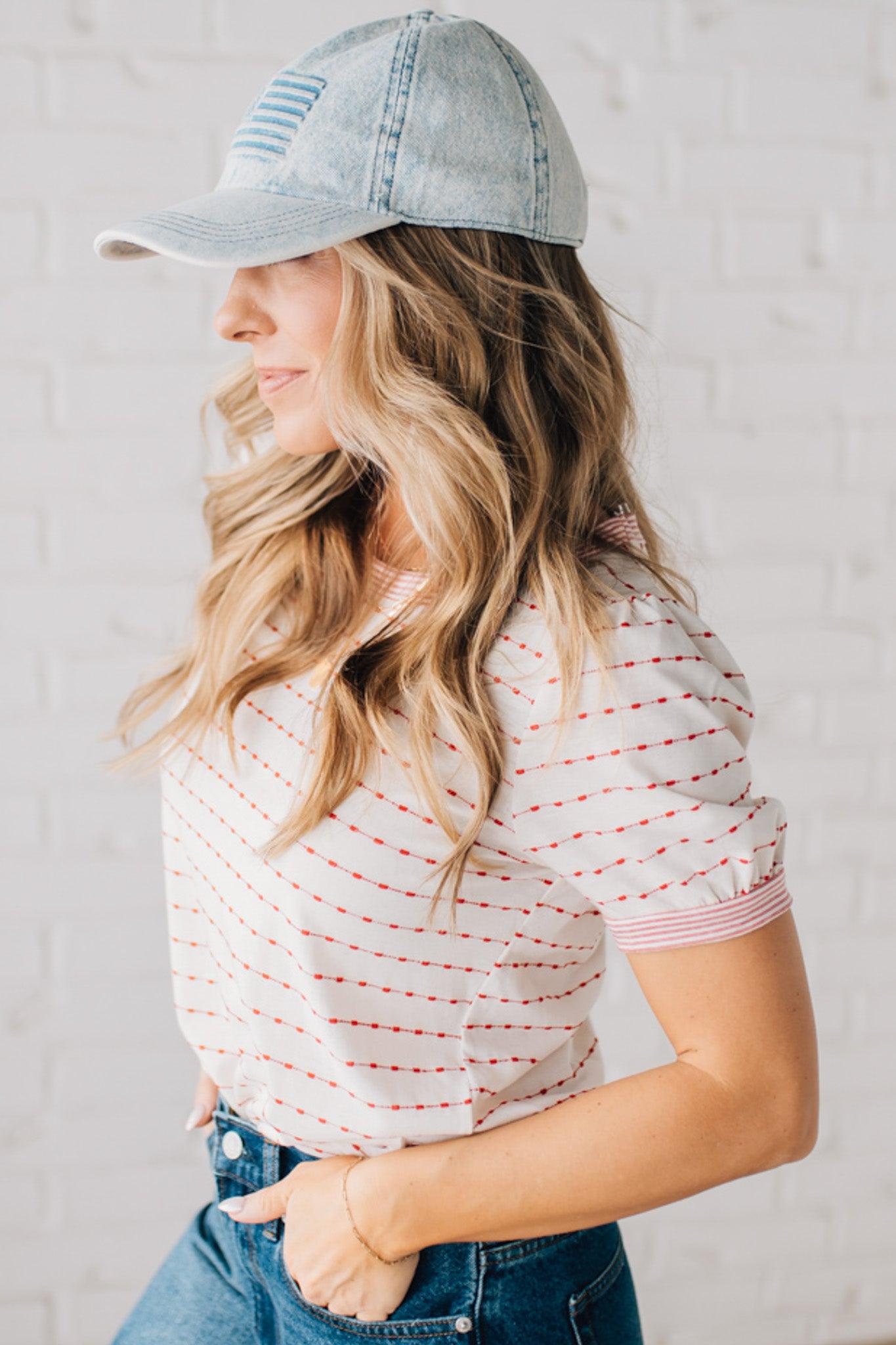 BLONDE WOMAN WEARING A STRIPE CONTRAST TRIMMED, PUFF SHORT SLEEVE, DOTTED STRIPE TOP IN WHITE AND RED.