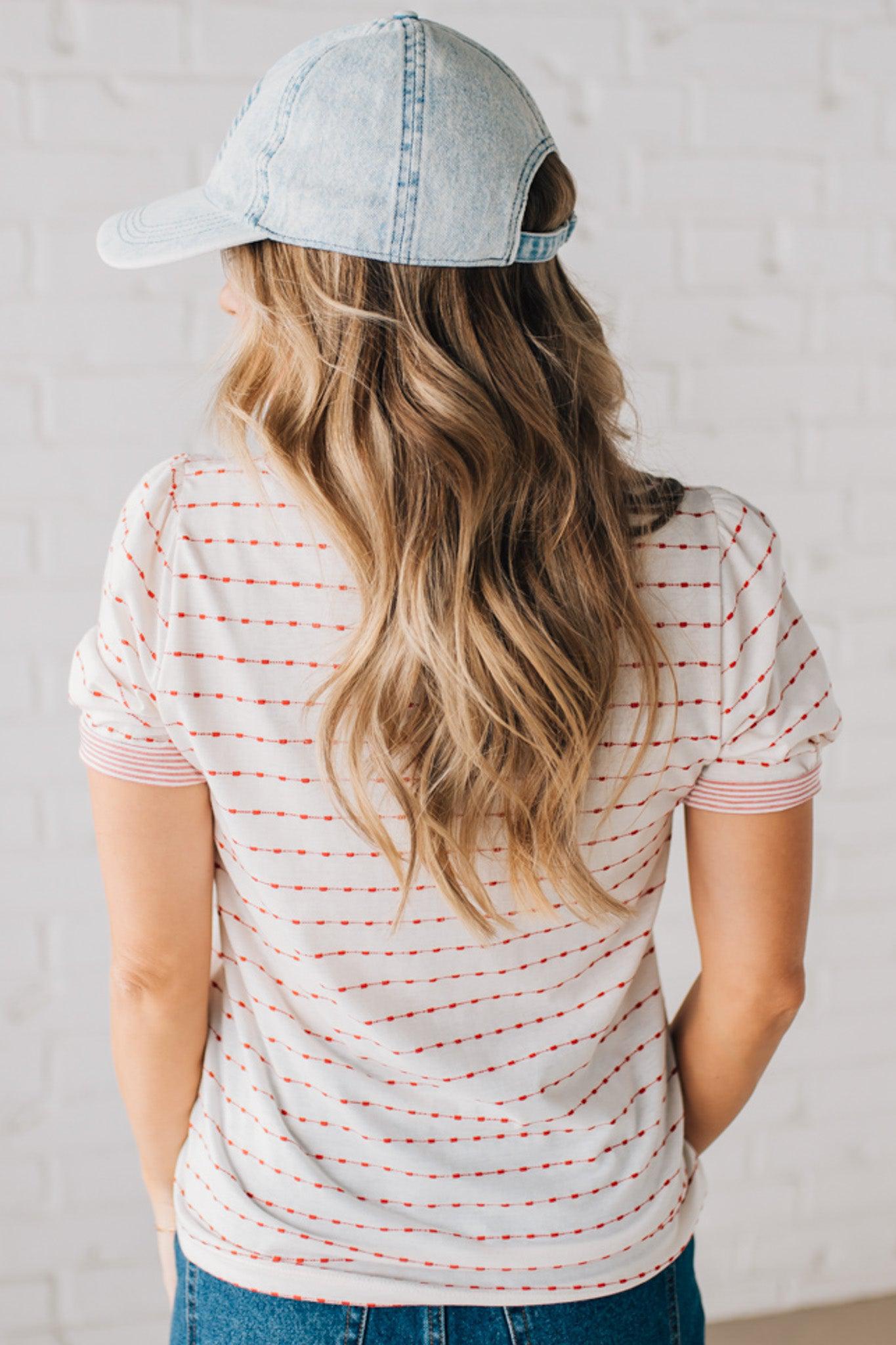 BLONDE WOMAN WEARING A STRIPE CONTRAST TRIMMED, PUFF SHORT SLEEVE, DOTTED STRIPE TOP IN WHITE AND RED.