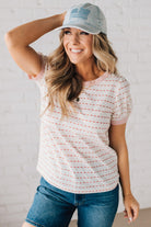 BLONDE WOMAN WEARING A STRIPE CONTRAST TRIMMED, PUFF SHORT SLEEVE, DOTTED STRIPE TOP IN WHITE AND RED.