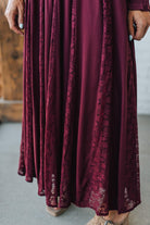 Maroon dress with lace details on a neutral background