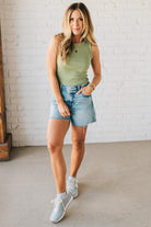 Woman wearing Acid Washed Raw Hem Shorts in Mid Rise.