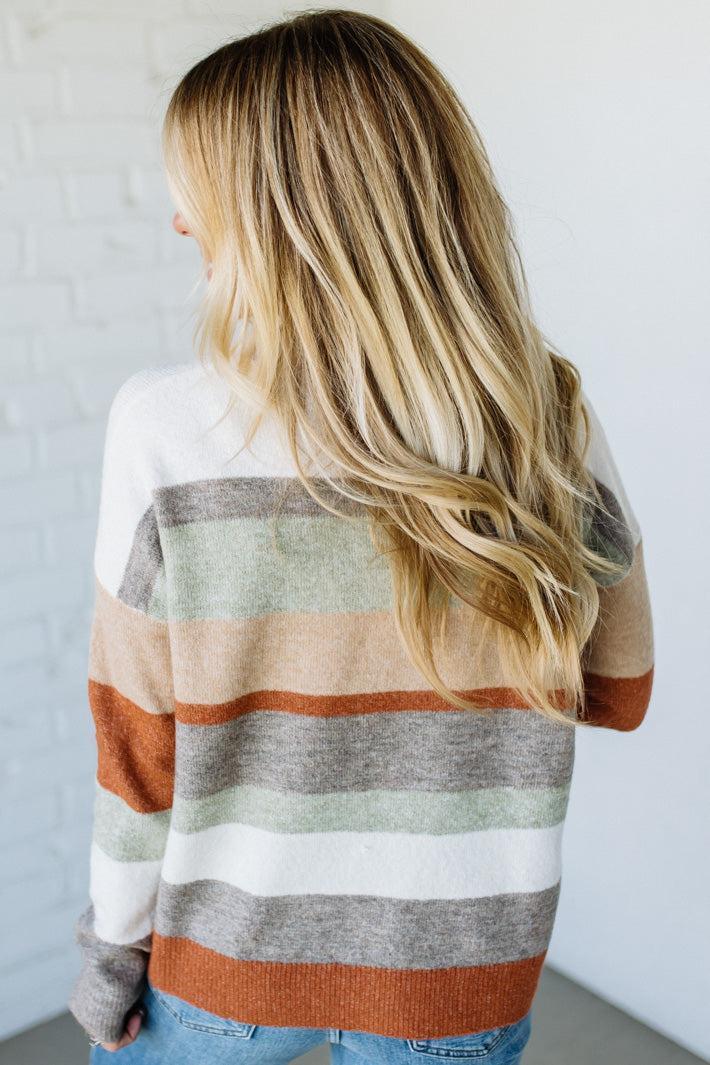 Person wearing a striped sweater with a neutral background