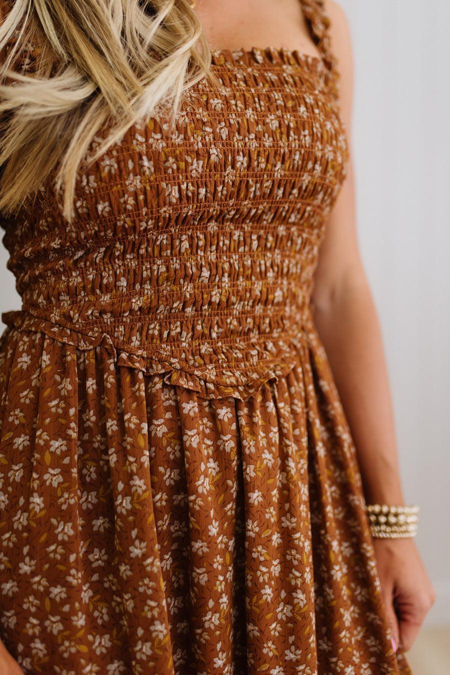 Brown floral dress worn by a person with a neutral background