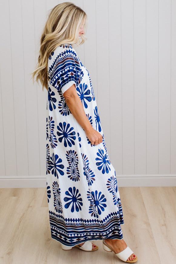 Woman wearing a blue and white patterned dress against a white background