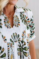 Woman wearing a white blouse with colorful floral patterns