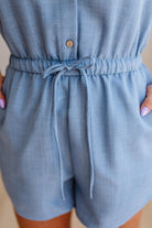 Light blue romper with a tie waist on a neutral background