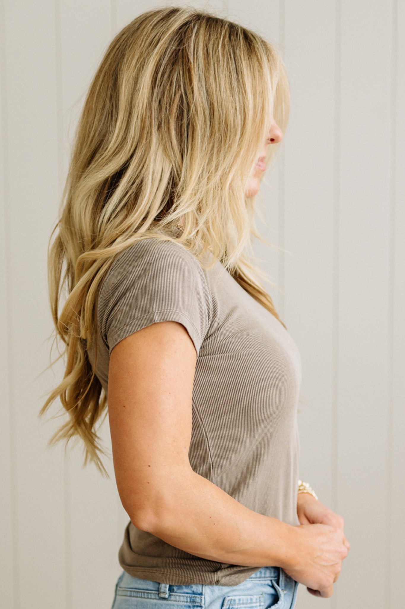 Woman wearing a brown t-shirt against a plain background