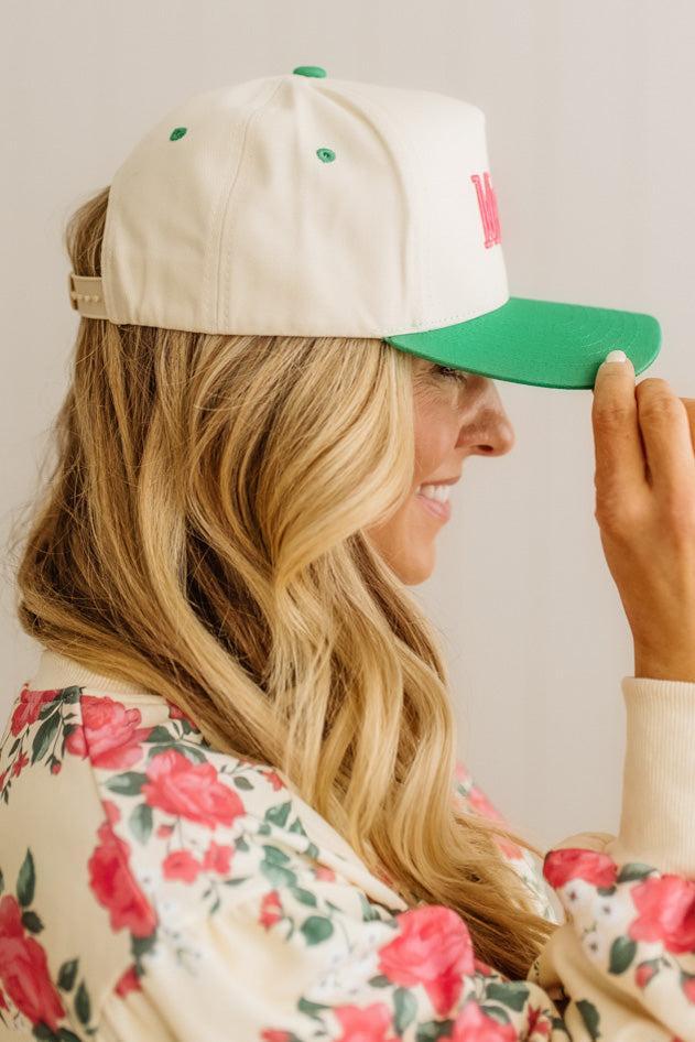 Woman wearing a beige and green cap with floral patterned clothing