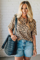 Woman holding a black nylon quilted traveler tote bag.