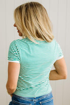 Woman wearing a green and white striped shirt against a plain background